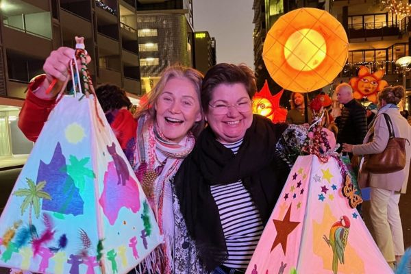Two women holding colourful lanterns at Luminous festival in Brisbane.
